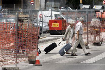 Dos viajeros van por la plaza dels Pa&iuml;sos Catalans, en una imagen de 2005.