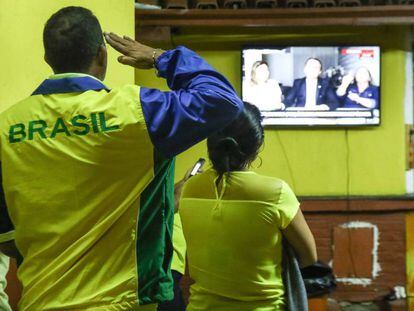 Un hombre saluda al televisor cuando Bolsonaro dio su discurso tras ganar las elecciones en Brasil.