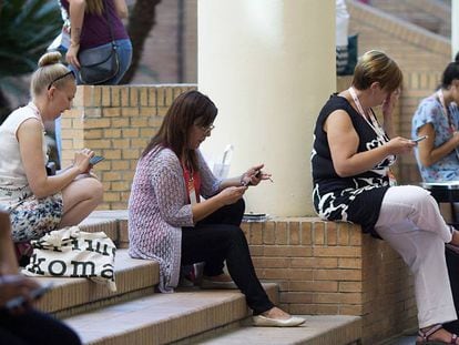 Mujeres participantes en el congreso EAIE 2017 usan el móvil.
