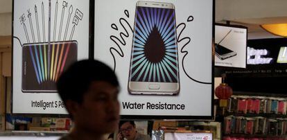 Un hombre pasa junto a un cartel promocional del Galaxy Note 7.