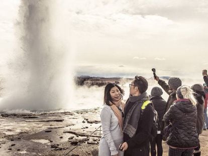 Unos turistas realizan fotos justo en el momento que erupciona el géiser Strokkur.