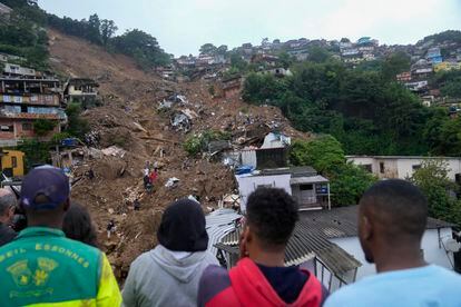 Rescatistas y residentes buscan víctimas en un área afectada por deslizamientos de tierra en Petrópolis, Brasil.