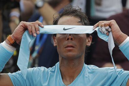 Rafael Nadal se ajusta la cinta para el pelo.