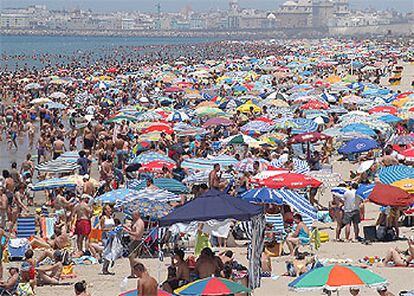 Vecinos de Cádiz y turistas, ayer a las 14.30, en la playa Victoria de la capital gaditana.