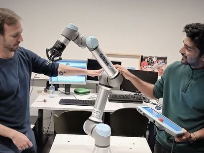Pablo Lanillos, coordinador científicio de METATOOL (izquierda) y el investigador postdoctoral Ajith Anil Meera con uno de sus robots industriales.