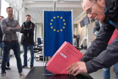 Un ciudadano europeo deposita su voto en una urna en Alemania.