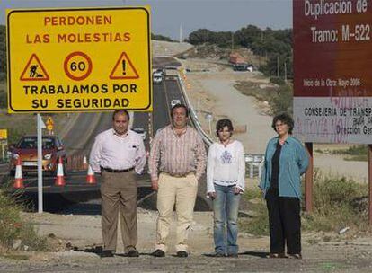 De izquierda a derecha, los alcaldes Pablo Martín (San Martín de Valdeiglesias) y Mario de la Fuente (Robledo de Chavela) y las ecologistas María Ángeles Nieto (Ecologistas en Acción) y Concha Velasco (Organización Sierra Oeste Desarrollo SOStenible) ante los carteles que avisan de las obras de duplicación en la <i>carretera de los pantanos.</i>