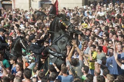Caragol des Born a Menorca. En una plaça atapeïda de gent, els 99 cavalls dels caixers fan bots espectaculars entre els milers de persones que l'omplen.