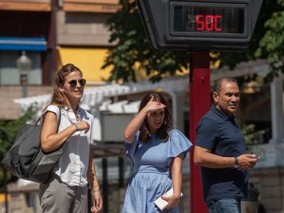 Varias personas pasan ante un termómetro al sol que marca 50 grados, ayer martes en Ourense, que supera las previsiones y llega a los 43,5 grados.