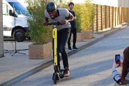 Usain Bolt montado en un patinete en París.