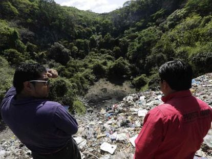 Dos personas observan el basurero de Cocula, Guerrero