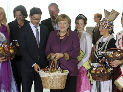 Angela Merkel y otros miembros de su Gobierno reciben manzanas en la Canciller&iacute;a durante una celebraci&oacute;n tradicional.