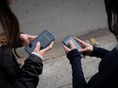 Dos personas utilizan teléfonos móviles en Barcelona, ​​Cataluña, España.