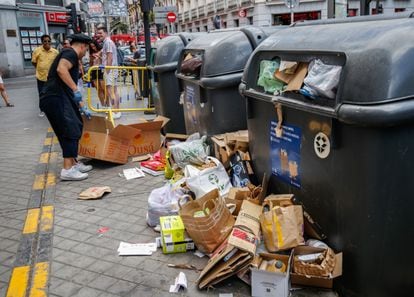 El dependiente de uno de los comercios de la Plaza de Tirso de Molina rompe las cajas para meterlas en el contenedor de reciclaje.