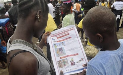 Niños liberianos leen un folleto para protegerse del ébola, en Monrovia.