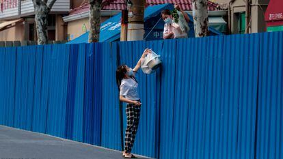 Una mujer en cuarentena recibe comida en la ciudad de Shanghái, este lunes.