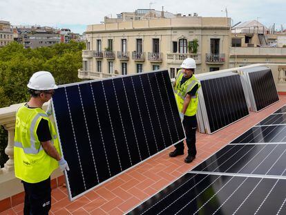 Dos operarios, en una instalación de paneles fotovoltaicos, en Barcelona.