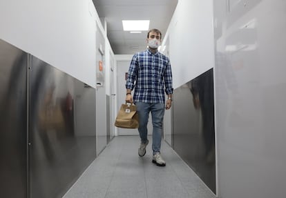 Juan Diego Gaitán lleva un pedido desde su "cocina fantasma" hasta la sala de espera del local donde lo espera un repartidor