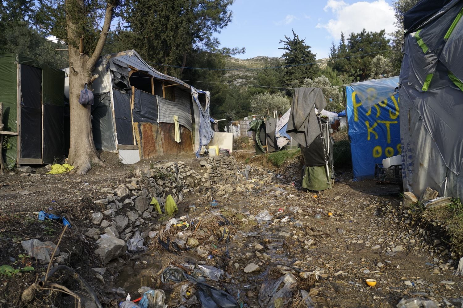 En Samos, unas 3.500 personas están hacinadas en un centro pensado para 648 en condiciones absolutamente miserables. La mayoría de ellos vive en tiendas de campaña improvisadas en el bosque junto a la instalación oficial, sin acceso a suficientes duchas e instalaciones sanitarias, así como refugios adecuados para mantenerse calientes. Las mujeres, los hombres y los niños no tienen otra opción que vivir en la tierra y la basura entre ratas y escorpiones. Hay cientos de personas que son vulnerables debido a sus graves problemas médicos o de salud mental y, sin embargo, permanecen atrapados en horribles condiciones durante meses.