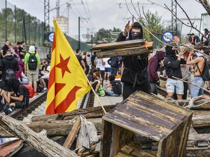 Un manifestante lanza madera para obstruir las vías del AVE durante la protesta contra la sentencia del 'procés' en Barcelona.