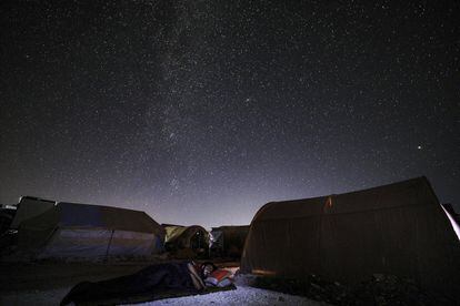 Maaret Misrin, provincia de Idlib, julio de 2020. Esta imagen de larga exposición muestra a un hombre durmiendo al aire libre bajo las estrellas en el campamento de personas desplazadas de Ahl al-Tah. <br><br> <i> “No había observado el cielo nocturno durante una década. En una noche de verano del año pasado, me sorprendió ver las estrellas por encima de la destrucción y los campamentos. La escena dividió el mundo por la mitad frente a mis ojos: una mitad mostraba lo que fue hecho por la mano de Dios y la otra, lo que fue creado por el hombre”.</i> <br>
