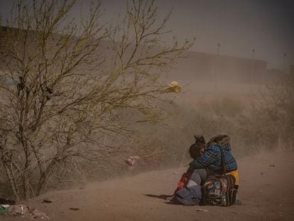 Una migrante se resguarda del polvo en la frontera de Ciudad Juárez (México) con Texas (Estados Unidos), el 30 de marzo