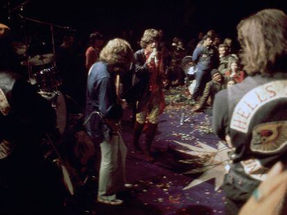 Mick Taylor, Mick Jagger y Keith Richards (al fondo, de rojo), durante su actuación en Altamont, en 1969, bajo la vigilancia de los Ángeles del Infierno.