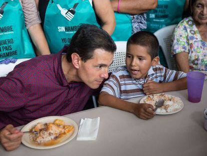 El presidente de México, Enrique Peña Nieto, habla con un niño durante una gira de trabajo en Michoacán realizada este martes.