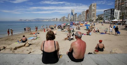 Una coppia di pensionati si gode il sole e le temperature calde sulla spiaggia Levante di Benidorm ad Alicante. 