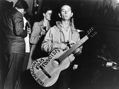 Retrato del músico de folk estadounidense Woody Guthrie con su guitarra en la que estaba escrito 'Esta máquina mata fascistas'.