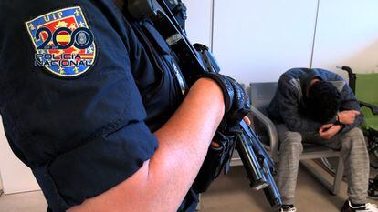 Un policía custodia fuertemente armado a 'El Pastilla' tras su llegada a Madrid, en una imagen facilitada por el Ministerio del Interior.