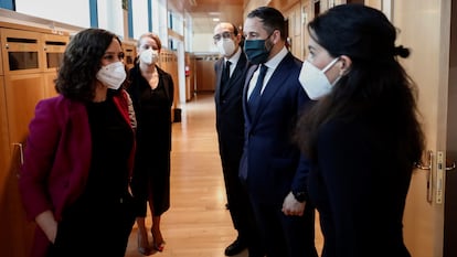 La presidenta de la Comunidad de Madrid, Isabel Díaz Ayuso conversa con la portavoz de Vox en la Asamblea, Rocío Monasterio en presencia del líder de Vox, Santiago Abascal.