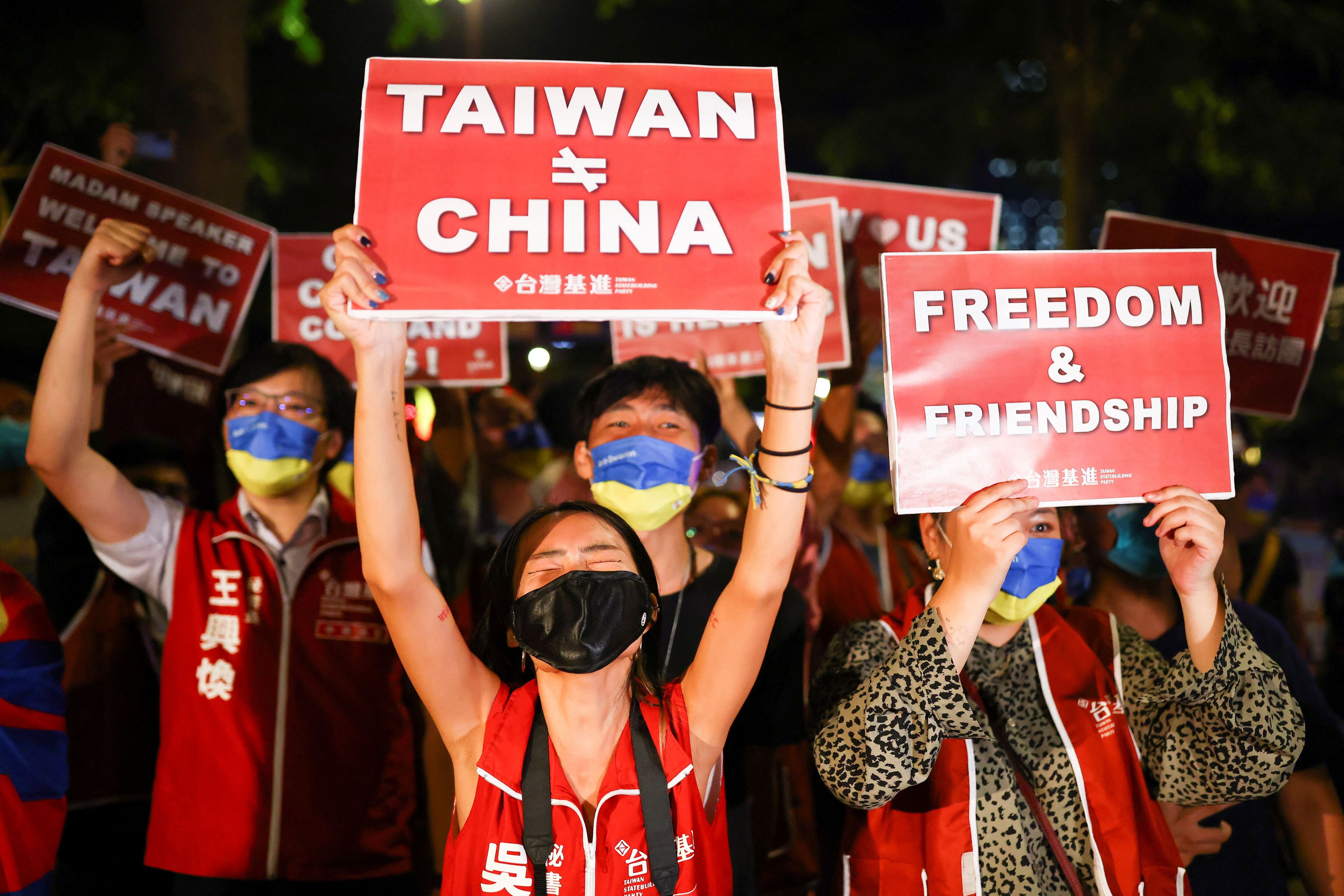 Manifestantes sostienen carteles durante una reunión en apoyo a la visita de Nancy Pelosi, en Taipéi.