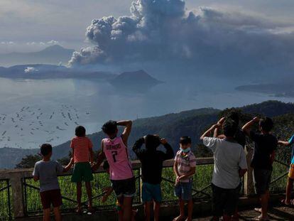 Un grupo de personas observa la erupción del volcán Taal este lunes en Tagaytay City (Filipinas). En vídeo, imágenes de la actividad del volcán.