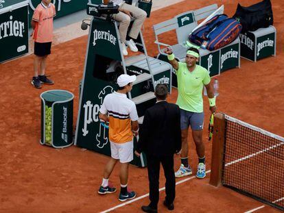 Nishikori y Nadal hablan con el supervisor antes de la suspensión, este martes en París.