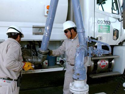 Trabajadores de Pemex abastecen combustible. 