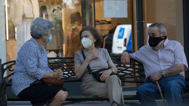 Dvd1003(27/05/20) Jubilados ataviados con mascarillas  conversan en un banco  , Madrid Foto: Víctor Sainz