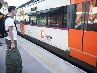 Uns usuaris esperen un tren del servei de Rodalies RENFE.