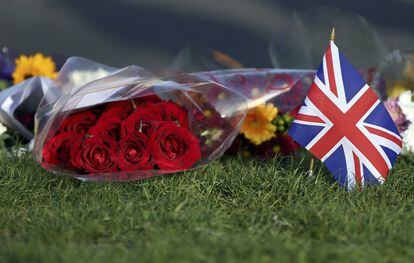 Flores y una bandera del Reino Unido frente al Parlamento.