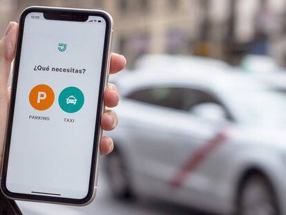 Una persona utiliza la aplicación de Joinup, que ahora incluye parkings además de taxis.