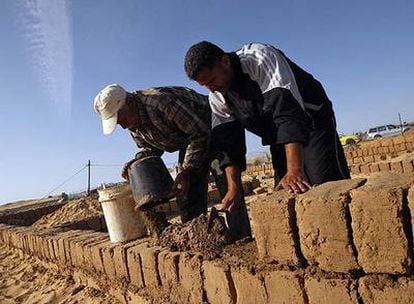 Dos palestinos construyen una casa de adobe en el campo de refugiados de Rafah, después de que la suya fuera destruida en la pasada operación militar israelí en Gaza