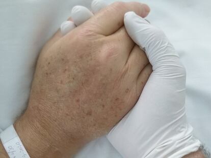 Francisco Izuzquiza coge la mano de su padre Javier en el hospital, en una imagen tomada por él mismo.