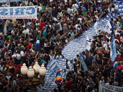 Miles de personas marchan hacia Plaza de Mayo con una gran pancarta con rostros de desaparecidos durante la última dictadura argentina.