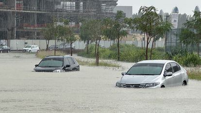Vehículos bajo el agua debido a las lluvias en las calles de Dubái, este martes.