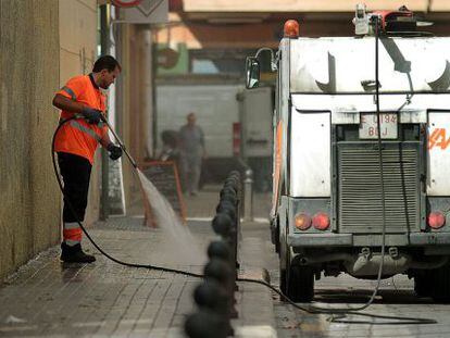 Un trabajador de Sociedad de Agricultores de la Vega realiza tareas de baldeo en una calle de Valencia.