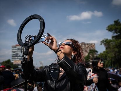 Una mujer observa el eclipse de sol anular que se vio de forma parcial en Ciudad de México el 14 de octubre De 2023.