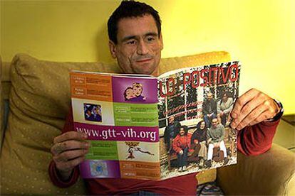 Xavier Franquet lee <i>Lo + positivo,</i> la revista sobre sida en la que trabaja, en su casa de Barcelona.