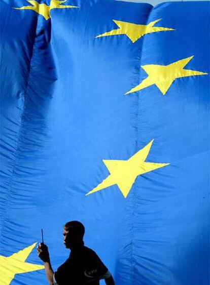 Un empleado, frente a una bandera de la UE en Bruselas.