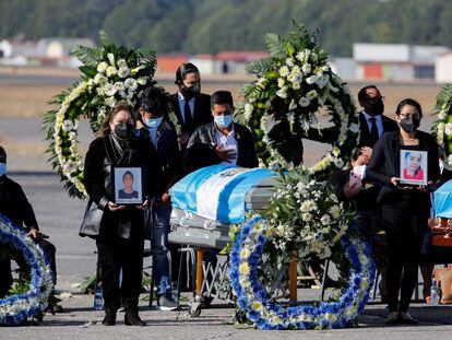 Familiares de los migrantes asesinados junto a sus restos, este viernes en Ciudad de Guatemala.