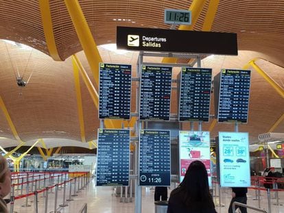 Dos pasajeras consultan los horarios en el aeropuerto de Madrid-Barajas. En vídeo, Delia Gutiérrez, promotora en change.org de la firma para poner fin al cambio estacional.